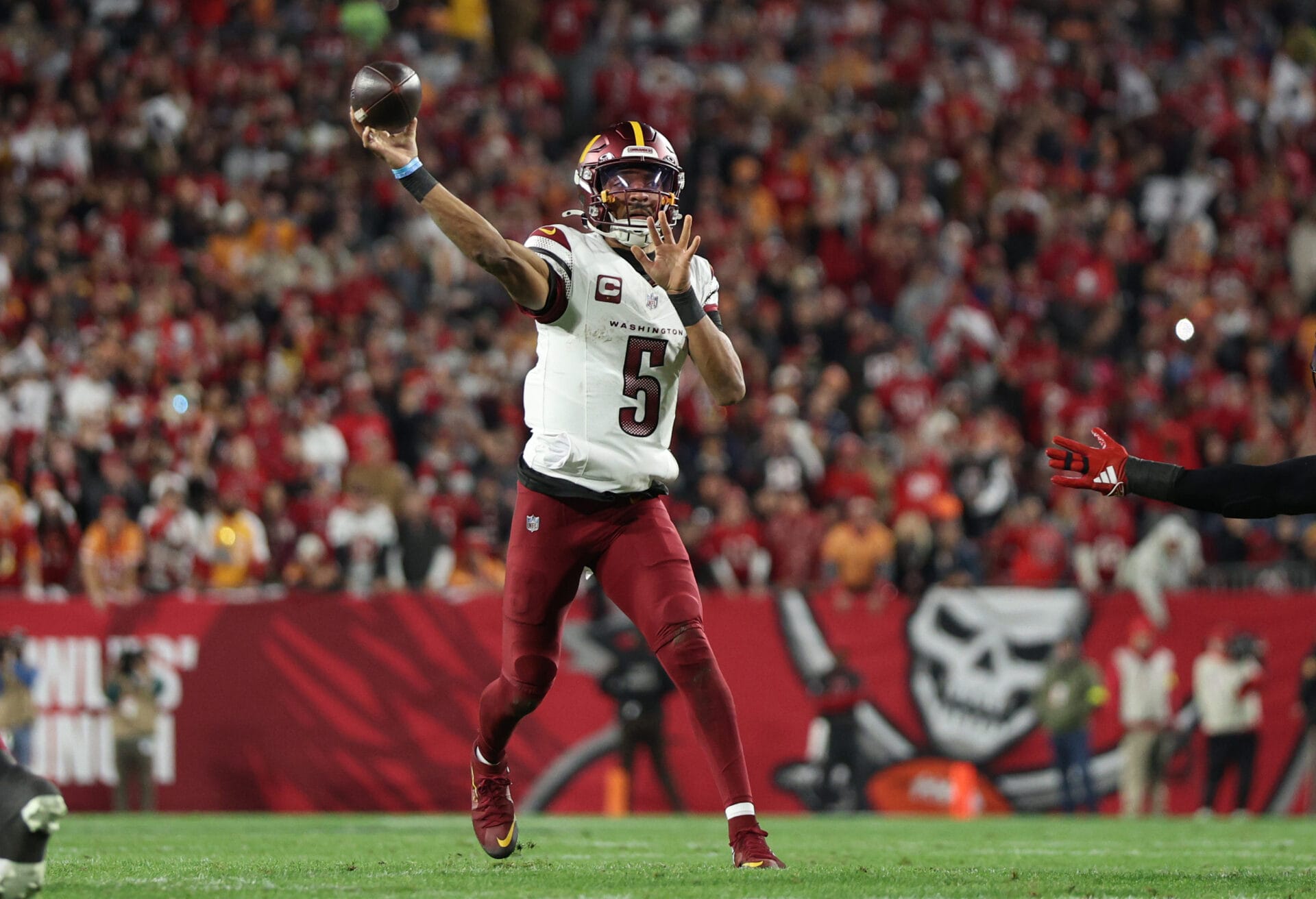 Jan 12, 2025; Tampa, Florida, USA; Washington Commanders quarterback Jayden Daniels (5) throws during the second quarter of a NFC wild card playoff against the Tampa Bay Buccaneers at Raymond James Stadium.