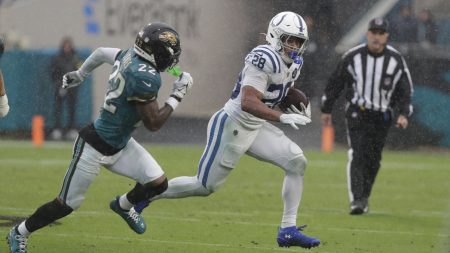 Dec 7, 2025; Jacksonville, Florida, USA; Indianapolis Colts running back Jonathan Taylor (28) carries the ball as Jacksonville Jaguars cornerback Jarrian Jones (22) during the first half at EverBank Stadium.
