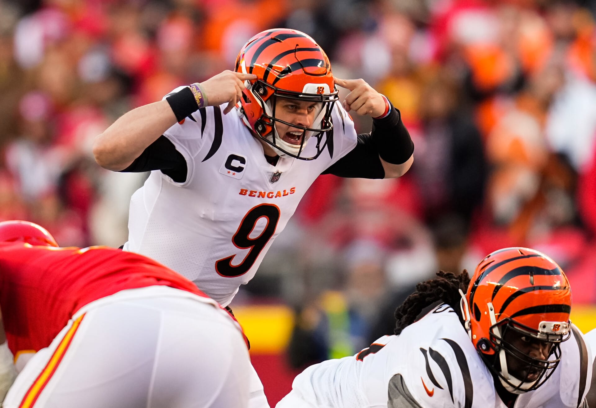 Cincinnati Bengals quarterback Joe Burrow points to his helmet with both index fingers to alert his teammates prior to a snap against the Kansas City Chiefs