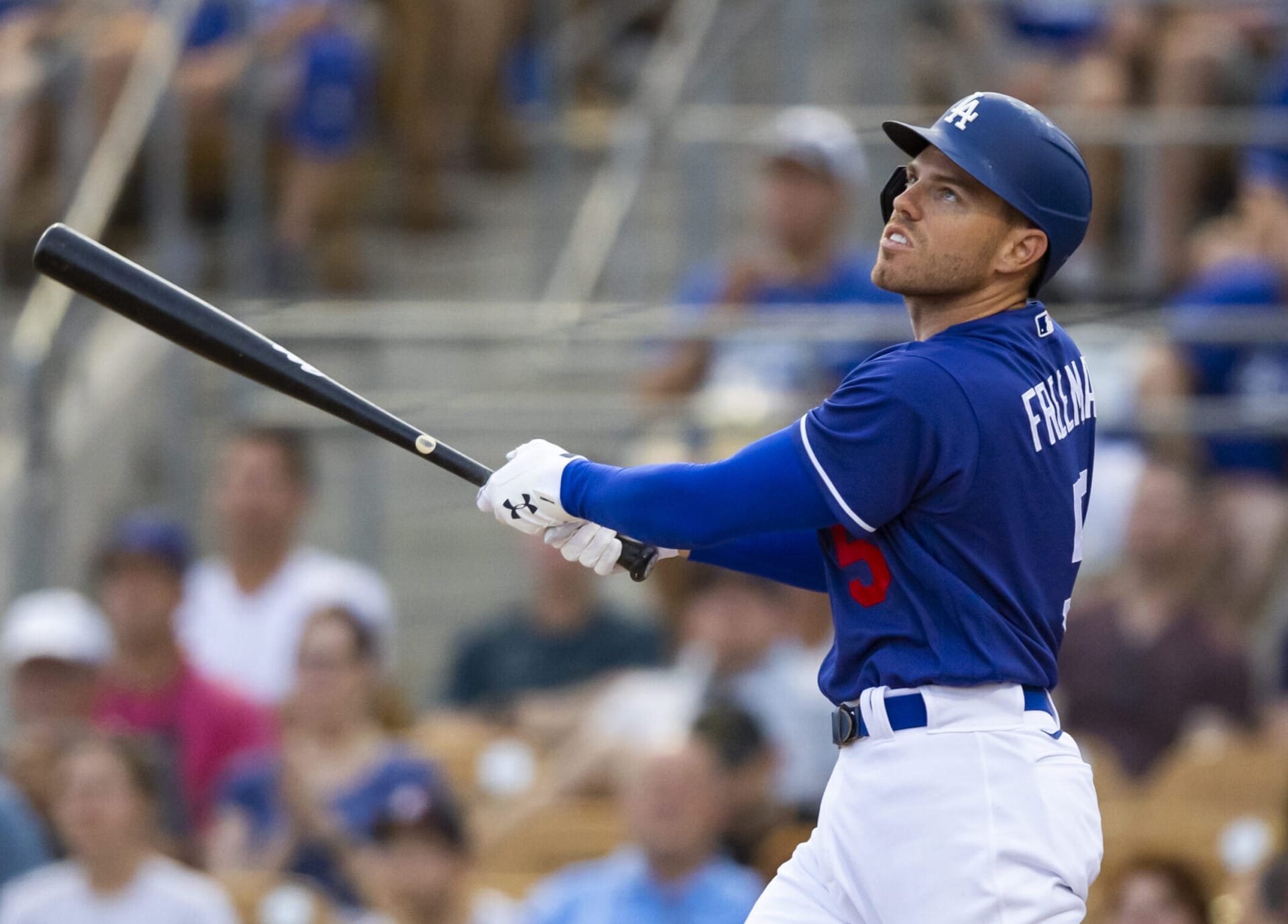 Los Angeles Dodgers first baseman Freddie Freeman follows through on a swing and watches the flight of the baseball after hitting a home run against the San Diego Padres during spring training